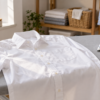 White button-down shirt laid on an ironing board beside a steam iron